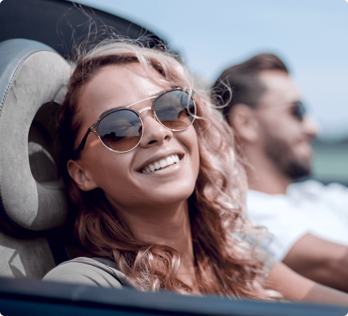 beautiful girl with fair hair is smilingly enjoying a safe driving ride in a car with her boyfriend in California They known for Clear2Drive Difference