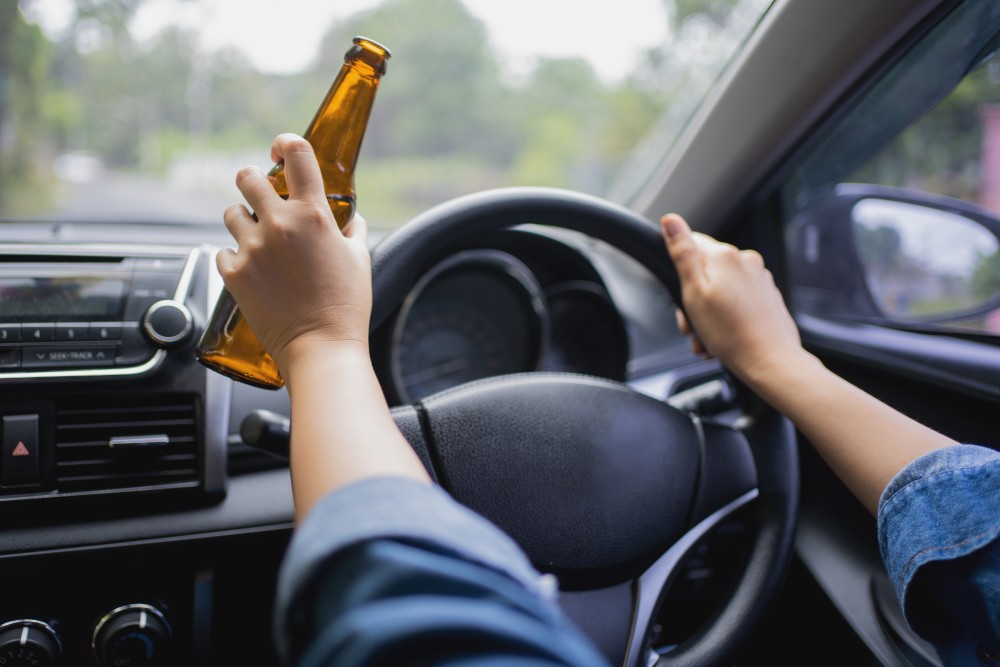 Woman,Is,Drinking,A,Bottle,Of,Beer,While,Driving,A